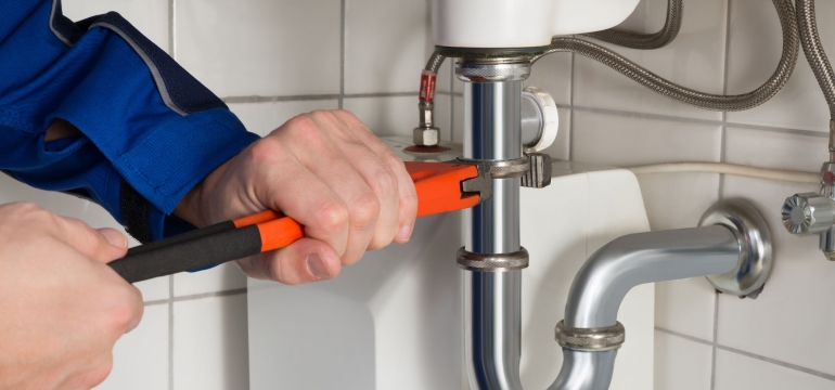 52751279 - close-up of male plumber repairing sink in bathroom